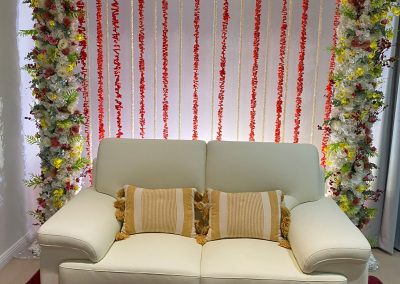 couch with floral arch and backdrop flower strands